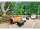 Outdoor wooden deck features seating arrangement with comfortable wicker chair surrounded by mature trees at 706 Briarleigh Sw Ct, Mableton, GA 30126