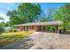 Well-maintained brick home with covered parking and lush green lawn at 205 Corinth Ct, Roswell, GA 30075