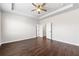 Bright bedroom featuring hardwood floors, ceiling fan, tray ceiling, and a neutral color scheme at 4325 Water Elm Aly, Doraville, GA 30360