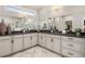 Bathroom with dual sinks, a large mirror, and a shower with white marble tile at 301 Sobeck Way, Canton, GA 30115