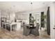 Open kitchen and dining area with hardwood floors, gray cabinets, and modern lighting fixtures at 301 Sobeck Way, Canton, GA 30115
