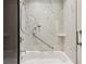 Bright bathroom with a marble tiled shower and grab bar for safety at 2660 Peachtree Nw Rd # 4G, Atlanta, GA 30305