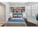 Inviting bedroom featuring hardwood floors, built-in bookshelves, and plantation shutters at 2660 Peachtree Nw Rd # 4G, Atlanta, GA 30305