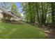 Lush green backyard featuring a well-maintained lawn and mature trees offering ample shade and privacy at 4979 Shadow Glen Ct, Dunwoody, GA 30338