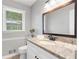 Charming bathroom featuring granite countertop, updated fixtures, and a framed mirror at 4979 Shadow Glen Ct, Dunwoody, GA 30338