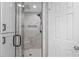 Shower with white marbled tiles, seamless glass enclosure, and built-in seat at 4979 Shadow Glen Ct, Dunwoody, GA 30338