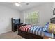 Bedroom featuring a dark wood bed with trundle, ceiling fan, and a window offering natural light at 4979 Shadow Glen Ct, Dunwoody, GA 30338