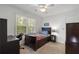 Cozy bedroom showcasing a dark wood bed, ceiling fan, and a large window offering natural light at 4979 Shadow Glen Ct, Dunwoody, GA 30338
