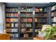 Beautiful bookcase with a ladder for accessing upper shelves, full of colorful books and decor at 4979 Shadow Glen Ct, Dunwoody, GA 30338