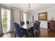 Formal dining room featuring a dark wood table, blue upholstered chairs, and a chandelier at 4979 Shadow Glen Ct, Dunwoody, GA 30338