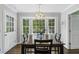 Dining room with hardwood floors, natural light, a dark wooden table, and modern chandelier at 4979 Shadow Glen Ct, Dunwoody, GA 30338