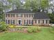 Charming brick home with black shutters, lush landscaping, and a well-maintained front lawn at 4979 Shadow Glen Ct, Dunwoody, GA 30338