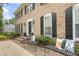 Classic brick home with black shutters, a well-manicured lawn, and outdoor seating for curb appeal at 4979 Shadow Glen Ct, Dunwoody, GA 30338
