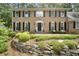Traditional brick home with black shutters and a beautifully landscaped front yard with stone retaining wall at 4979 Shadow Glen Ct, Dunwoody, GA 30338
