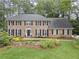 Classic brick home featuring a manicured lawn, lush landscaping, and symmetrical design at 4979 Shadow Glen Ct, Dunwoody, GA 30338