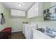 Laundry room with storage cabinets, sink, washer, dryer and hardwood floors at 4979 Shadow Glen Ct, Dunwoody, GA 30338