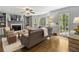 Cozy living room with a fireplace, built-in shelves, and a large window with natural light at 4979 Shadow Glen Ct, Dunwoody, GA 30338