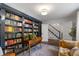 Study with extensive library shelving, a writing desk, and comfortable seating for a home office space at 4979 Shadow Glen Ct, Dunwoody, GA 30338