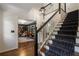 Staircase with hardwood steps and runner, leading to a library with bespoke built-in shelving and reading nook at 4979 Shadow Glen Ct, Dunwoody, GA 30338