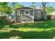 Backyard and exterior featuring lush grass, mature trees, and gray painted brick at 1258 Lyle Ave, Atlanta, GA 30344