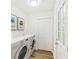 Bright laundry room with a front load washer and dryer and decorative wall art at 1258 Lyle Ave, Atlanta, GA 30344