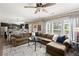 Spacious living room with hardwood floors, a ceiling fan, and a large sectional sofa near the open-concept kitchen and dining area at 357 Ridgewood Trl, Canton, GA 30115