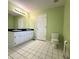 Tiled bathroom with double sink vanity, white cabinets, and a well-lit mirror at 4003 Preston Place Ln, Powder Springs, GA 30127