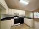 Functional kitchen with white cabinets, black appliances, and tile backsplash at 4003 Preston Place Ln, Powder Springs, GA 30127