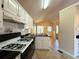 Clean kitchen with white cabinets, black appliances, and views to the breakfast nook at 4003 Preston Place Ln, Powder Springs, GA 30127