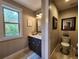 Bathroom with a marble countertop vanity and sink, plus a window and a partitioned area with a toilet at 7350 Banks Mill Rd, Douglasville, GA 30135
