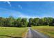 Scenic driveway leading to the home, surrounded by lush greenery and trees at 7350 Banks Mill Rd, Douglasville, GA 30135