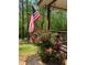 Cozy porch featuring vibrant red roses, an American flag, and views of the surrounding greenery at 7350 Banks Mill Rd, Douglasville, GA 30135