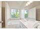 Modern bathroom features a large window above a tub and a shower area, providing natural light and comfort at 275 Carriage Chase, Fayetteville, GA 30214