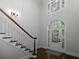 Elegant foyer with staircase, hardwood floors, and a beautiful arched doorway with decorative glass at 5900 Fords Nw Rd, Acworth, GA 30101