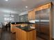 Open kitchen features stainless steel refrigerator, kitchen island, granite counters, and view to dining room at 5900 Fords Nw Rd, Acworth, GA 30101