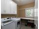 Efficient laundry room features white washer and dryer and extra cabinet space at 5900 Fords Nw Rd, Acworth, GA 30101