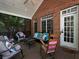 Cozy screened porch featuring brick exterior, ceiling fan, and comfortable seating with decorative pillows at 5900 Fords Nw Rd, Acworth, GA 30101