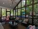 Relaxing screened porch with vaulted ceiling, ceiling fan, and a view of the sparkling pool and lush, wooded backyard at 5900 Fords Nw Rd, Acworth, GA 30101