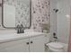 Stylish bathroom with floral wallpaper, white vanity, and shower-tub combination at 1468 Briarwood Ne Rd # 703, Atlanta, GA 30319