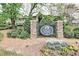 Entrance sign for Carlyle Woods Condominium, surrounded by lush landscaping and mature trees at 1468 Briarwood Ne Rd # 703, Atlanta, GA 30319