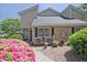 Charming tan townhouse features a beautiful front yard with vibrant pink flowers and a cozy seating area at 1468 Briarwood Ne Rd # 703, Atlanta, GA 30319