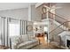 Bright living room featuring a staircase, fireplace, and open access to the dining area for seamless entertaining at 1468 Briarwood Ne Rd # 703, Atlanta, GA 30319