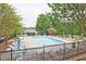 Community pool with abundant seating and a surrounding fence and trees, creating a private oasis at 1468 Briarwood Ne Rd # 703, Atlanta, GA 30319