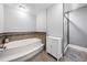 Bright bathroom featuring a modern bathtub and tiled walls and floors, with a shower behind a sliding glass door at 2784 Sixes Rd, Canton, GA 30114