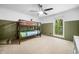 Well-lit bedroom with bunk beds, a ceiling fan, and a large window overlooking a green landscape, two tone walls at 2784 Sixes Rd, Canton, GA 30114
