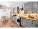 Stylish kitchen with gray cabinetry, wood countertops, stainless steel appliances and adjacent dining area at 2784 Sixes Rd, Canton, GA 30114