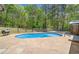 An inground pool surrounded by a concrete patio and a wooden fence against wooded views at 2784 Sixes Rd, Canton, GA 30114