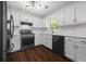 Modern kitchen with stainless steel appliances, marble backsplash, and dark hardwood floors at 2990 Williams Farm Dr, Dacula, GA 30019