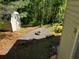 This backyard features a fire pit, shed, landscaping, and is surrounded by a lush green forest at 5679 Coopers Glen Ct, Mableton, GA 30126