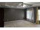 Spacious bedroom featuring soft carpet, neutral walls, a ceiling fan, and natural light from the windows at 5679 Coopers Glen Ct, Mableton, GA 30126